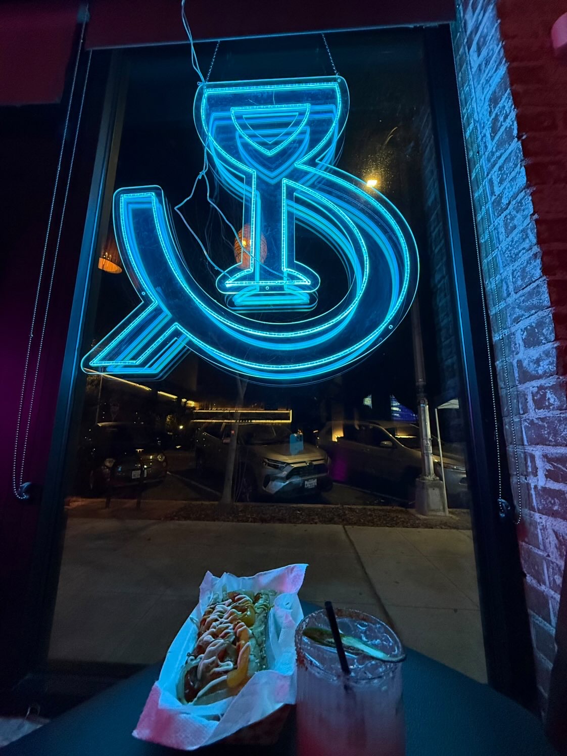 Tower Hotdog and drink beneath a neon sign — Fresno street vibes