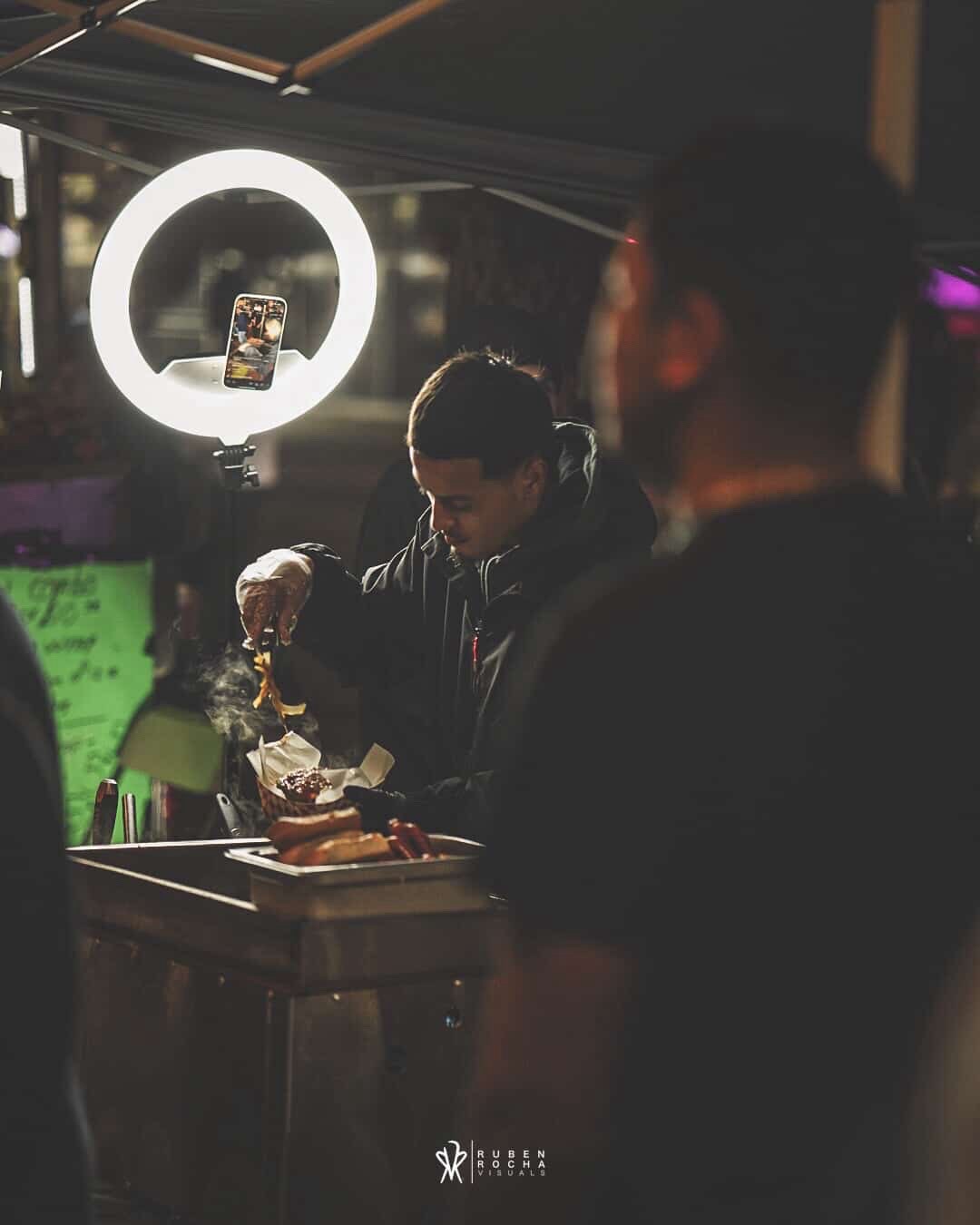 Tower Hotdogs owner at the grill — ring light, late night